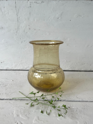 vaso piccolo ocra trasparente forma cilindrica con una parte superiore liscia e dritta, mentre la base è più ampia e bombata
